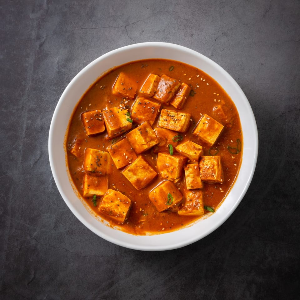 Everest Indian Kitchen's paneer dish, with paneer cubes in a rich orange sauce, garnished with seeds.