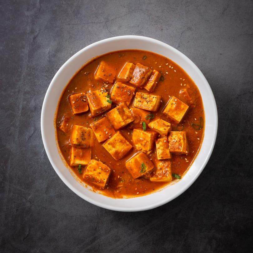 Everest Indian Kitchen's paneer dish, with paneer cubes in a rich orange sauce, garnished with seeds.